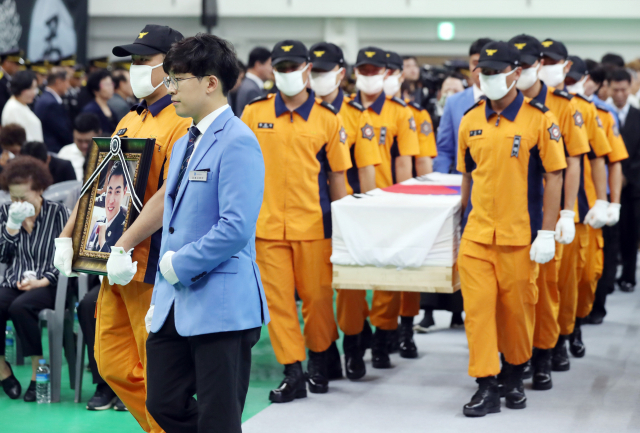 16일 오전 경기도 김포시 마산동 김포생활체육관에서 열린 고(故) 오동진 소방위과 심문규 소방장의 합동 영결식에서 오 소방위와 심 소방장의 시신이 운구되고 있다. 연합뉴스