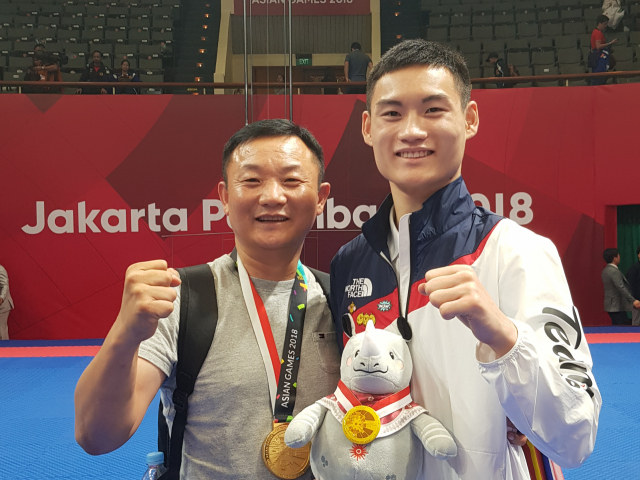 19일 태권도 품새 남자 개인에서 금메달을 목에 걸며 한국에 첫 금빛 승전보를 전한 강민성이 경기가 끝난 후 아버지 강도윤 씨와 포즈를 취하고 있다. 김병훈 기자