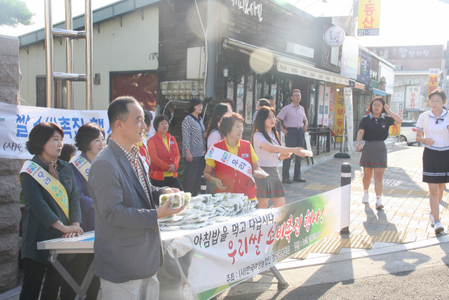 한국여성농업인 청도군연합회가 20일 청도 모계중고에서 쌀 소비촉진 행사를 갖고, 등교하는 학생들에게 떡을 나눠주고 있다. 모계중고 제공