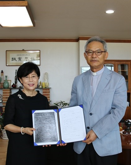 김문영(왼쪽) 교수가 장학금과 나이팅게일 선서 동판을 정일 총장 신부에게 전달하고 있다. 가톨릭상지대학교 제공