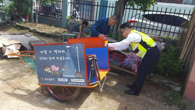 경주경찰서 직원이 노인 교통사고 예방을 위해 폐지 수거용 손수레에 경고등과 반사지를 부착하고 있다. 경주경찰서 제공