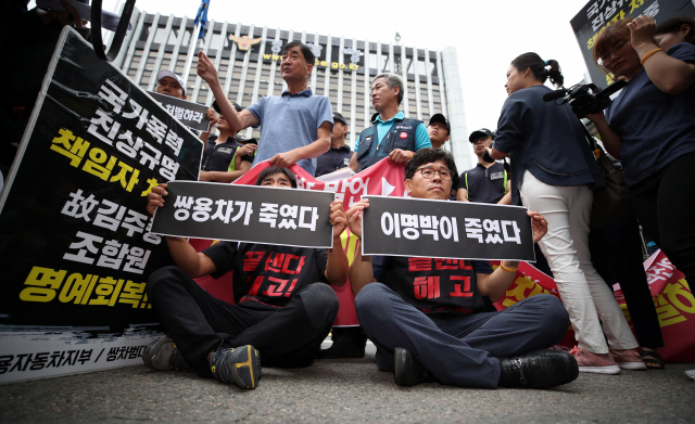 28일 오전 서울 서대문구 경찰청 앞에서 열린 경찰청 인권침해사건 진상조사위원회 쌍용차 진압 보고서 발표에 따른 입장발표 기자회견에서 전국금속노동조합 쌍용자동차지부 조합원들이 기자회견장 장소를 놓고 경찰과 승강이를 벌이자 한상균 전 민주노총 위원장(오른쪽)이 자리에 앉고 있다. 연합뉴스