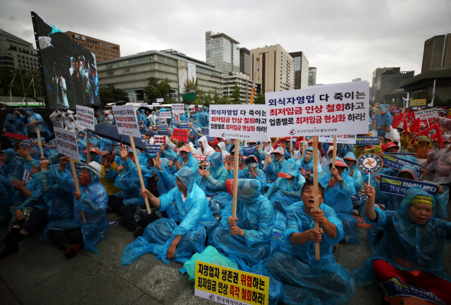 29일 오후 서울 광화문광장에서 열린 전국 소상공인 최저임금 제도개선 촉구대회에서 참가자들이 최저임금 인상 철회를 요구하고 있다. 연합뉴스