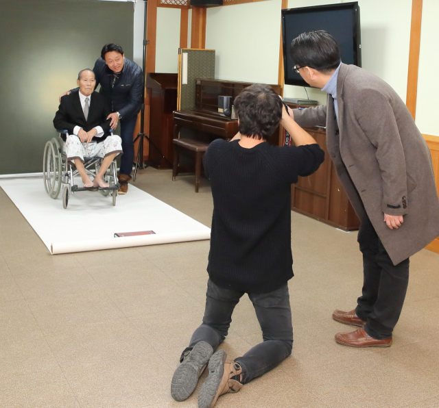 한국사진작가협회 칠곡지부 회원들이 3일 칠곡군립노인요양병원에서 이모 할아버지의 장수사진을 찍고 있다. 이현주 기자