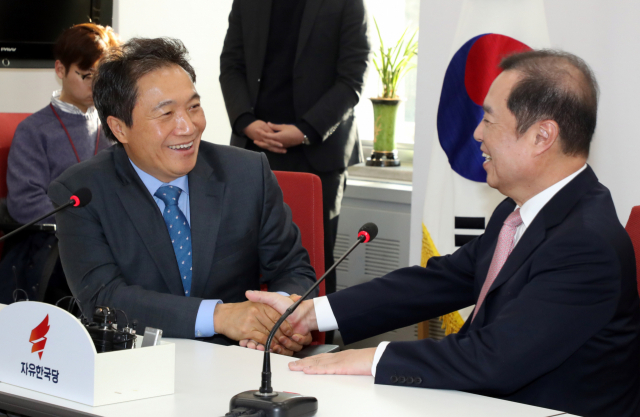 자유한국당 복당이 예정된 바른미래당 이학재 의원이 18일 국회에서 자유한국당 김병준 비상대책위원장과 면담하며 손을 잡고 대화하고 있다. 연합뉴스