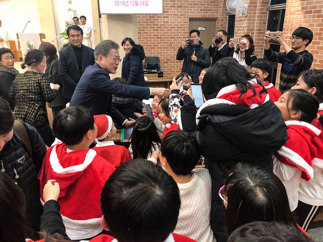 문재인 대통령이 24일 오후 경남 양산시 덕계 성당에서 열린 성탄 전야 미사에 참석해 어린이들과 인사하고 있다. 연합뉴스