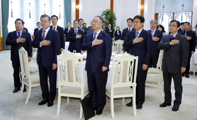 문재인 대통령이 26일 오후 청와대에서 열린 국민경제자문회의에서 위원들과 함께 국기에 경례하고 있다. 연합뉴스