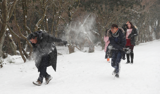 제주 산간에 많은 눈이 내린 28일 오전 제주시 한밝저수지 인근에서 가족 단위로 제주를 찾은 외국인 관광객들이 눈싸움하며 즐겁게 뛰어놀고 있다. 연합뉴스 #제주공항