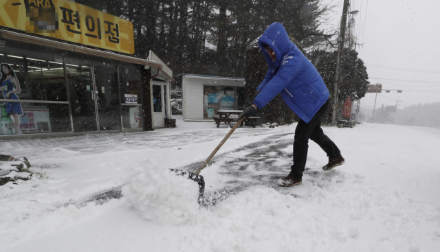 제주 산지에 대설주의보가 내려진 28일 오전 제주시 아라동 한 편의점 앞에서 제설작업이 이뤄지고 있다. 연합뉴스 #제주공항