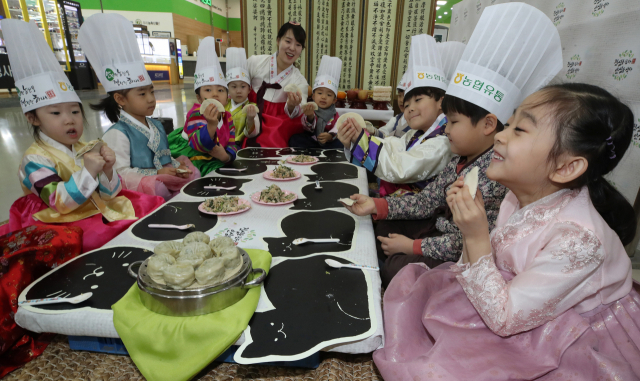 21일 오전 서울 서초구 농협하나로마트에서 한복을 입은 어린이들이 설 차례상에 올릴 만두를 빚고 있다. 연합뉴스