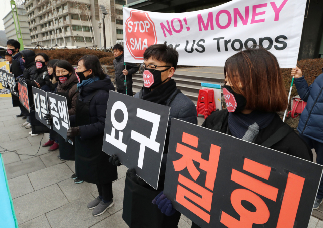 31일 오후 서울 종로구 광화문KT 앞에서 평화와통일을여는사람들 회원들이 미국의 방위비 분담금 인상 요구 철회를 촉구하는 손팻말을 들고 있다. 연합뉴스