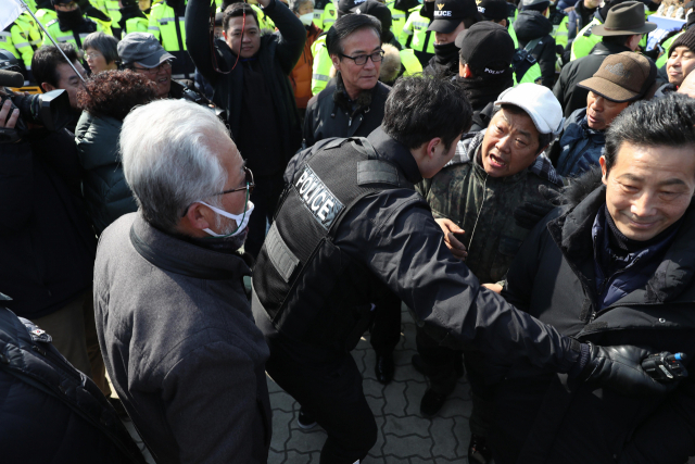 자유한국당 김진태 의원 지지자들(왼쪽)과 5.18 유족단체 관계자들이 13일 오후 국회 정문 앞에서 각각 집회하던 중 충돌하고 있다. 연합뉴스