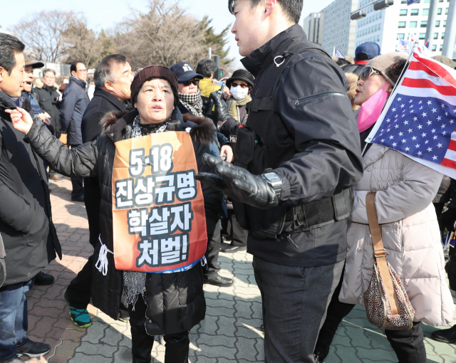 자유한국당 김진태 의원 지지자들(오른쪽)과 5.18 유족단체 관계자들이 13일 오후 국회 정문 앞에서 각각 집회하던 중 충돌하고 있다. 연합뉴스