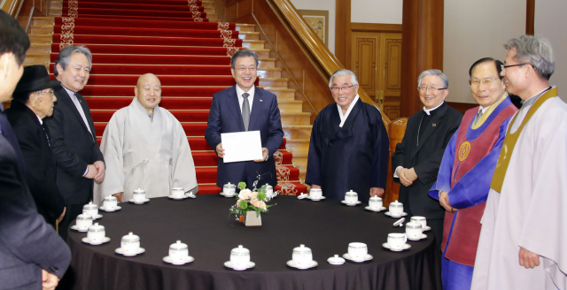 문재인 대통령이 18일 낮 청와대에서 7대 종단 지도자들과 오찬을 함께하기에 앞서 열린 차담회에서 참석자들과 얘기를 나누며 웃음 짓고 있다. 왼쪽부터 민족종교협의회 박우균 회장, 한국기독교교회협의회 이홍정 총무, 조계종 원행 총무원장, 문 대통령, 김영근 성균관장, 한국천주교주교회의 의장 김희중 대주교, 이정희 천도교 교령, 오도철 원불교 교정원장. 연합뉴스