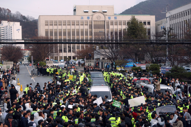 11일 전두환 전 대통령이 5·18 민주화운동 관련 형사재판 출석을 마치고 광주지방법원을 빠져나가자 시위대가 법원 진입로를 메우며 항의하고 있다. 연합뉴스