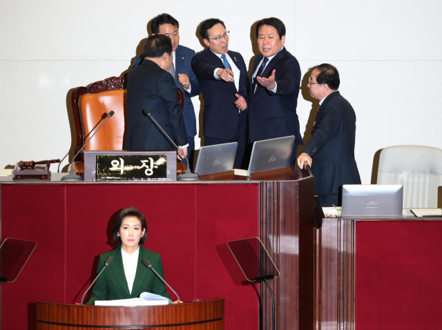 자유한국당 나경원 원내대표가 12일 오전 국회 본회의장에서 교섭단체 대표연설을 하던 중 정부가 북한의 대변인이라는 식의 발언을 하자 더불어민주당 홍영표 원내대표(뒷줄 가운데)가 단상으로 나가 강하게 항의하고 있다. 연합뉴스