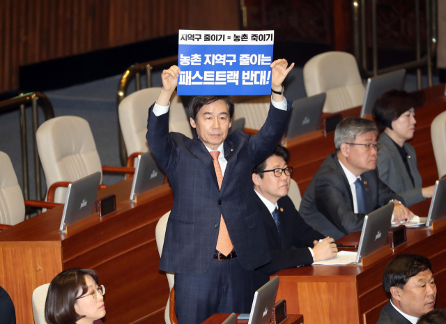 무소속 이용호 의원이 12일 국회 본회장에서 자유한국당 나경원 원내대표 교섭단체 대표연설에 앞서 패스트트랙 반대를 요구하며 손팻말 시위를 하고 있다. 연합뉴스