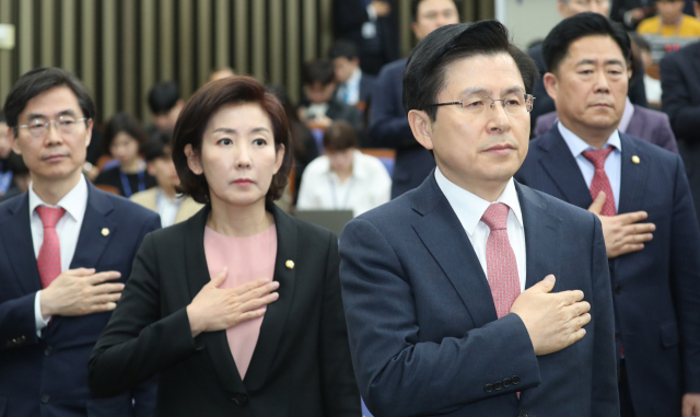 13일 자유한국당 황교안 대표(오른쪽부터)와 나경원 원내대표가 국회에서 열린 의원총회에서 국기에 경례하고 있다. 연합뉴스