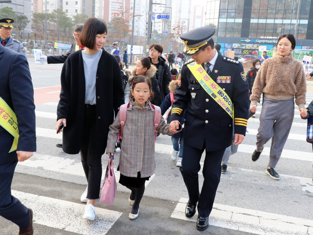 예천경찰서 신동연 서장이 등교하는 초등생들의 손을 잡고 안전하게 횡단보도 건너기 체험 교육을 하고 있다. 예천경찰서 제공