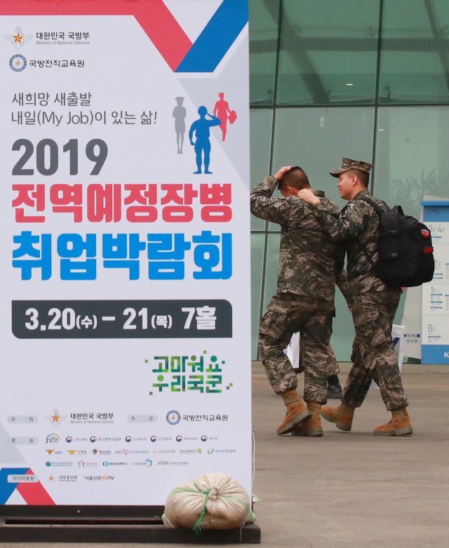 20일 경기도 고양시 킨텍스 제2전시장에서 열린 2019 전역예정장병 취업박람회를 찾은 한 전역 예정 장병이 박람회장으로 들어가는 동료를 격려해 주고 있다. 연합뉴스