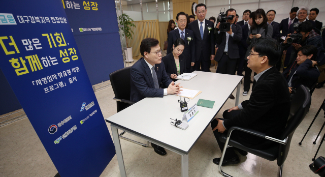 최종구 금융위원장이 25일 오전 대구 신서혁신도시 신용보증기금 본사에서 열린 은행권 사회공헌사업 업무협약식을 마친 후 자영업자와 보증상담을 하고 있다. 김영진 기자 kyjmaeil@imaeil.com