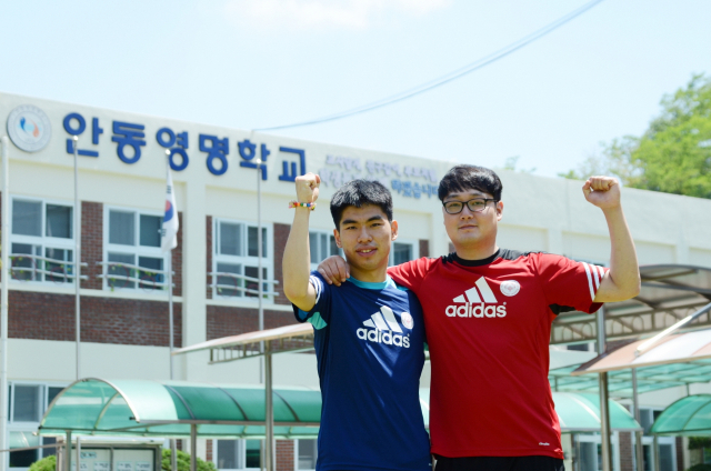 안동영명학교 김명재 선수(사진 왼쪽)와 조보근 코치가 파이팅을 외치며 포즈를 취하고 있다. 김 선수는 올해 스페셜올림픽 세계하계대회 100m에서 동메달을 획득했다. 안동영명학교 제공