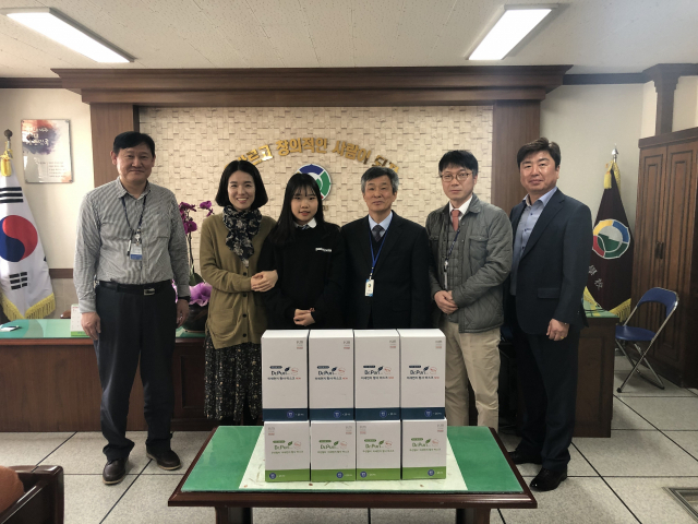 구미 봉곡중학교 이소민(2학년·왼쪽에서 3번째) 학생과 학교 관계자들이 27일 주식회사 케이엠 신병순 대표로부터 초미세먼지·황사를 방지할 수 있는 닥터퓨리 마스크 1만장을 받고 기념촬영을 하고 있다. 봉곡중학교 제공