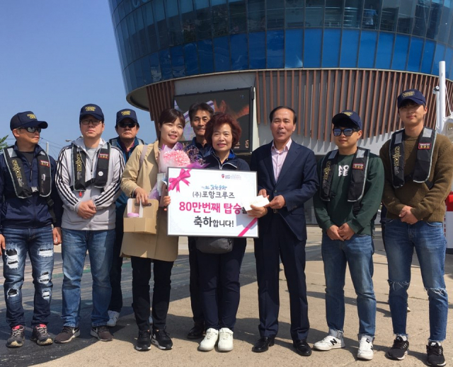 80만명째 행운을 차지한 이순희 씨 가족이 기념꽃다발을 받고 있다. 포헝크루즈 제공