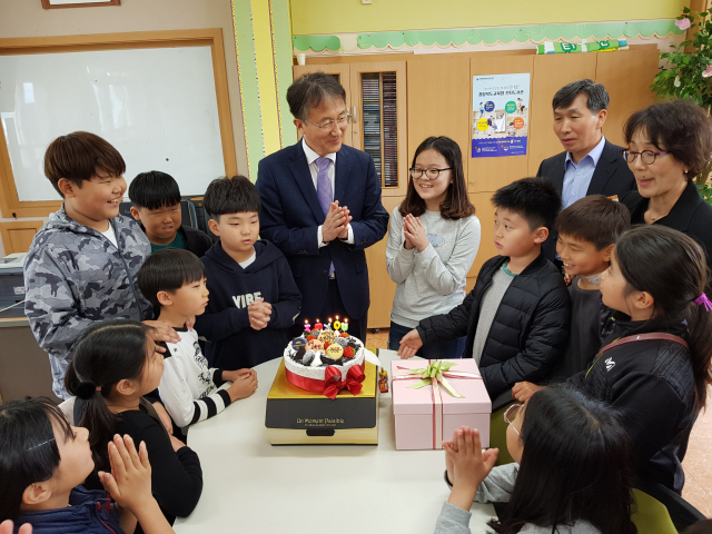 권순길 칠곡교육지원청 교육장(가운데)이 숭산초등학교 어린이들과 함께 케이크에 촛불을 켜고 박수 치고 있다. 칠곡교육지원청 제공