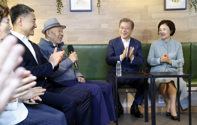 문재인 대통령과 김정숙 여사가 7일 오전 서울 금천구 치매안심센터에서 치매 어르신과 가족 및 관계자들과 간담회 도중 치매에 걸린 아내를 위해 역대 최고령 요양보호사 자격증을 딴 최대식 할아버지의 얘기를 듣고 있다. 연합뉴스