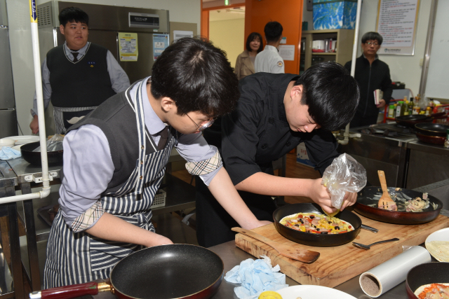 문명고 학생들이 대구한의대 학생강사의 지도에 따라 요리를 배우고 있다. 대구한의대 제공