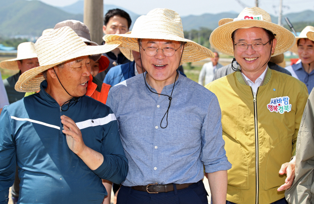 문재인 대통령이 24일 오전 경북 경주시 옥산마을에서 모내기를 마친 뒤 주민들과 대화를 나누며 이동하고 있다. 김영진 기자 kyjmaeil@imaeil.com