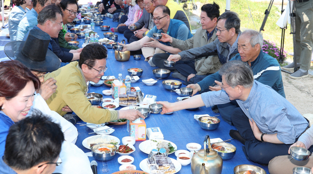 이철우(왼쪽) 경북도지사가 24일 경주 모내기 체험 행사에 온 문재인 대통령에게 새참 시간을 이용해 지역 현안 건의를 하면서 막걸리 잔을 부딪히고 있다. 김영진 기자 kyjmaeil@imaeil.com