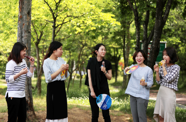 이틀째 광주에 폭염주의보가 발효 중인 16일 오후 광주 북구 문흥근린공원에서 직장인들이 아이스크림을 먹으며 더위를 잊고 있다. 연합뉴스