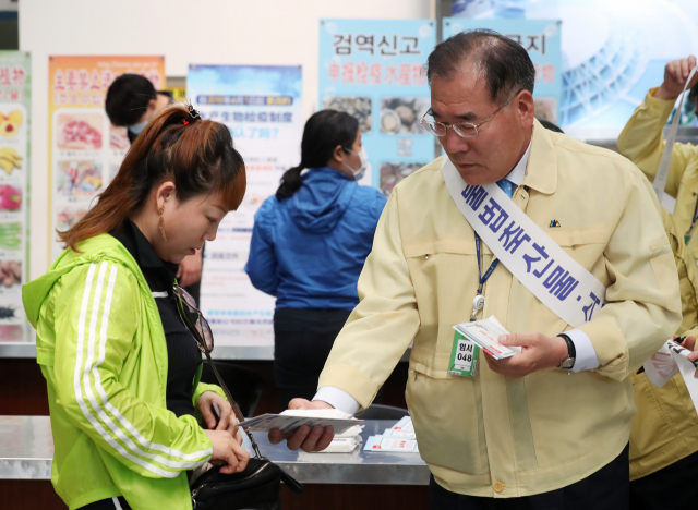 이개호 농림축산식품부 장관이 3일 오후 인천시 중구 인천항 제2국제여객터미널 입국장에서 중국 관광객들을 상대로 아프리카돼지열병(ASF) 유입을 막기 위한 불법 축산물 검역을 홍보하고 있다. 법정 제1종 가축전염병인 아프리카돼지열병은 돼지에게만 감염되는 치명적인 전염병으로 백신이나 치료법이 없다. 연합뉴스