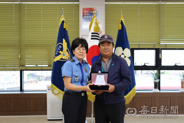 불이 난 선박에 다가가 승선원 전원을 무사히 구조한 공로로 D호 선장 김모(62)씨에게 울진해양경찰서 박경순 서장이 감사패를 전달하고 있다. 울진해경 제공