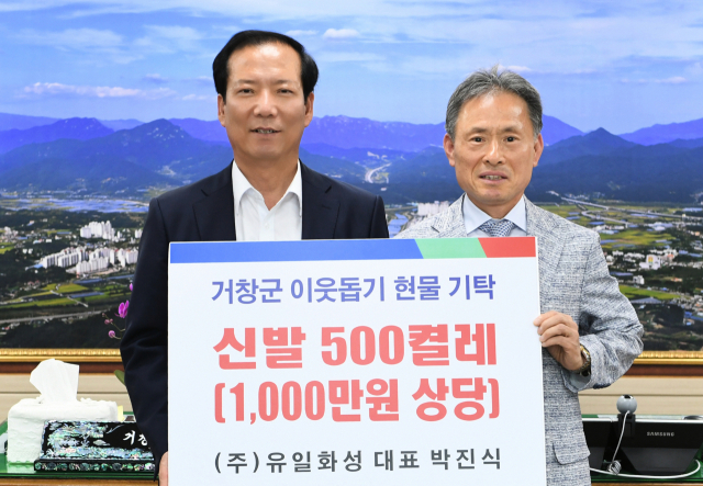 박진식(오른쪽) 대표가 구인모 군수에게 신발 500컬레를 전달했다. 거창군청 제공