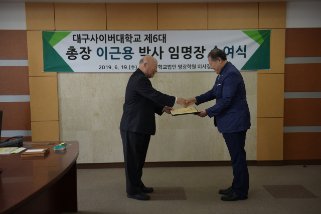 19일 학교법인 영광학원 이사장실에서 열린 임명장 수여식에서 이근용 대구사이버대학교 신임 총장(오른쪽)이 박윤흔 이사장에게 임명장을 받고 있다. 대구사이버대 제공.