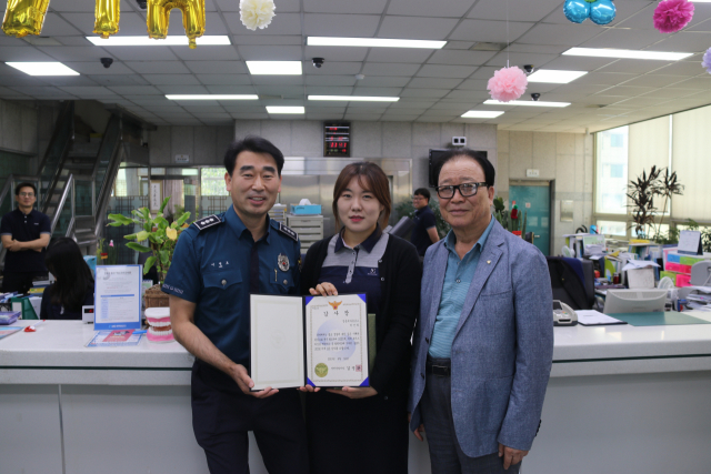 영천경찰서 이병호 생활안전과장이 보이스피싱 피해를 막은 영동새마을금고 여직원에게 감사장을 전달하며 기념촬영을 하고 있다. 영천경찰서 제공