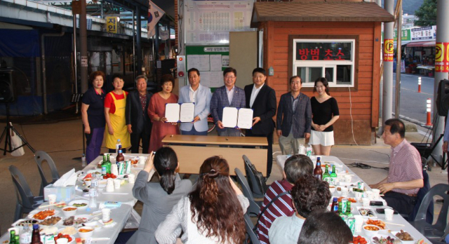 영남대학교 경산시동창회가 27일 오후 경산공설시장 광장에서 전통시장 기 살리기 및 동문화합 한마당 잔치를 열고 경산공설시장상인회와 업무협약을 체결하고 기념사진을 찍었다. 영남대 경산시동창회 제공