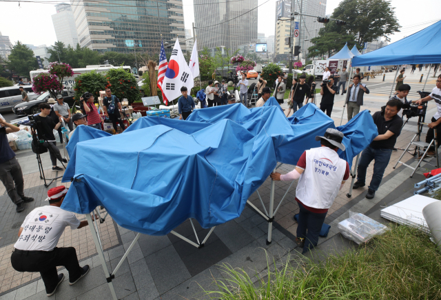 우리공화당(구 대한애국당) 당원들이 28일 오후 광화문광장에 설치한 천막을 청계광장 일대로 이동 설치하고 있다. 연합뉴스