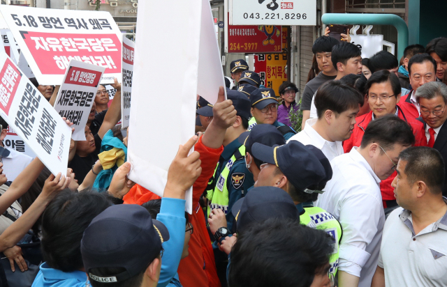 자유한국당 황교안 대표가 지난달 14일 오후 충북 청주시 상당구 한 커피점에서 학부모 간담회를 마치고 나가던 중 민주노총 충북지역본부 조합원들이 자유한국당 해체를 요구하며 시위를 벌이자 경찰의 도움을 받아 빠져나가고 있다. 연합뉴스