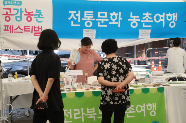 5일 서울 청계광장에서 열린 공감농촌 페스티벌 농림축산식품부 도농교류의 날 여름 휴가 캠페인에서 방문객들이 각 지역 부스를 둘러보고 있다. 연합뉴스