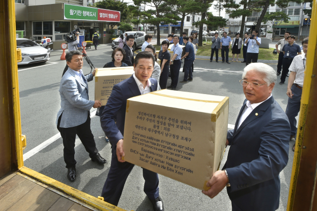 조재구 남구청장과 홍대환 남구의장이 24일 오전 남구청 광장에서 몽골 울란바타르 시로 보낼 의류를 선적하고 있다. 대구 남구청 제공.