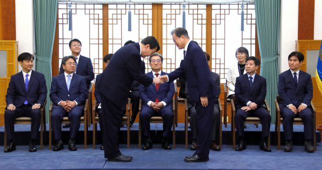 문재인 대통령이 25일 오전 청와대에서 윤석열 신임 검찰총장에게 임명장을 수여한 뒤 악수하고 있다. 연합뉴스