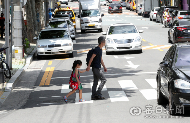 30일 대구 동천초등학교 부근에서 한 학부모가 아이와 함께 신호등 없는 횡단보도를 조심스레 건너고 있다. 성일권 기자 sungig@imaeil.com