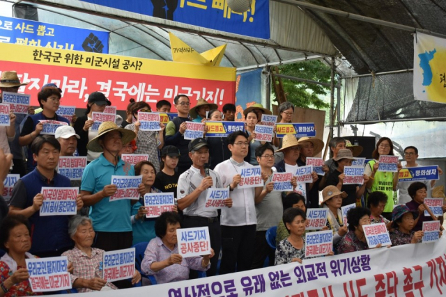 31일 사드철회 평화회의의 사드기지 내 공사 중단 촉구 기자회견 참석자들이 공사 중단 등의 내용이 담긴 손팻말을 들고 있다. 사드철회 평화회의 제공