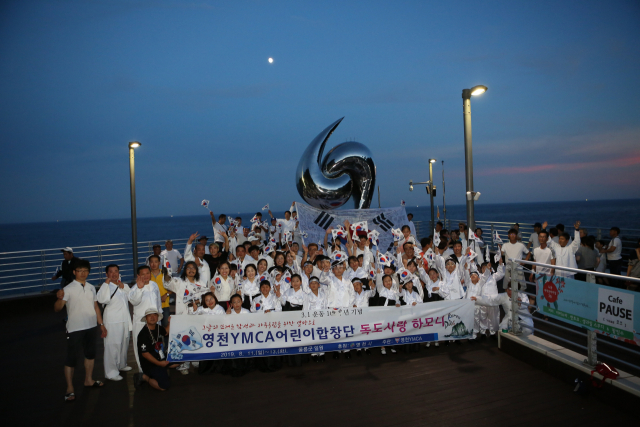 영천YMCA 어린이합창단 단원 등이 11~13일 울릉도 도동항 야외공연장에서 독도사랑 하모니 공연을 마친 후 우리 땅 독도의 영유권 수호의지와 함께 우리 영토에 대한 소중함을 되새기며 태극기를 흔들고 있다. 영천YMCA 제공