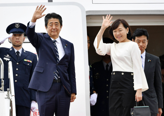 아베 신조 일본 총리가 23일 부인 아키에 여사와 함께 프랑스에서 열리는 선진 7개국(G7) 정상회의 참석을 위해 전용기편으로 하네다공항에서 출국하기에 앞서 손을 들어 인사하고 있다. 연합뉴스