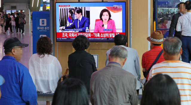 2일 오후 서울역 대합실에서 시민들이 조국 법무부 장관 후보자 기자간담회와 자유한국당 나경원 원내대표의 기자회견 장면을 시청하고 있다. 연합뉴스